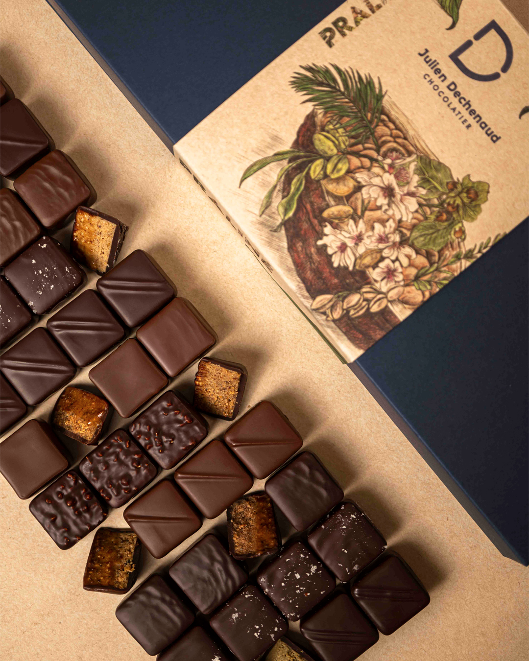 Assortiment de 44 pralinés au chocolat noir et chocolat au lait : amande, noisette, coco et amande-noisette feuilleté, un assortiment gourmand et hautement savoureux imaginé par le chef Julien Dechenaud chocolatier à Paris et Vincennes.